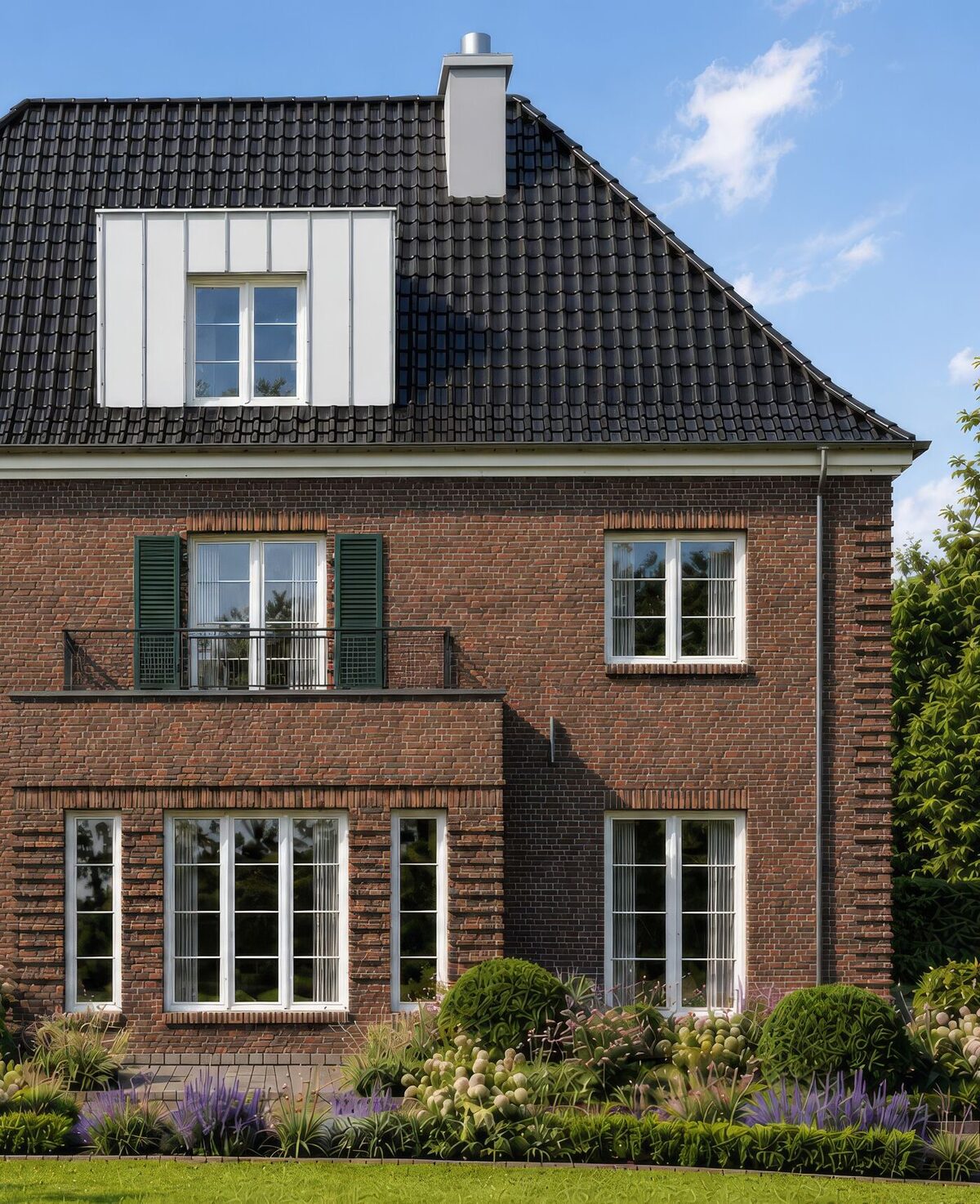 Fassadendetail der Villa: Rotklinker, Erker mit Balkon und weiße Sprossenfenster
